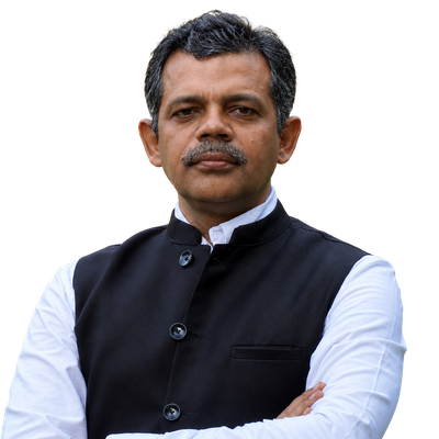 Portrait of a middle-aged man in a black Nehru-style vest and white shirt, arms crossed, looking at the camera.