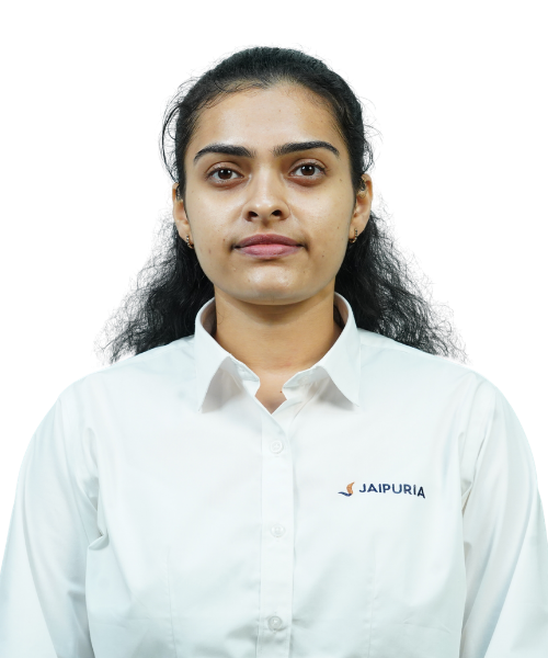 Portrait of a woman in a white collared shirt with the Jaipuria logo, facing the camera with a neutral expression.