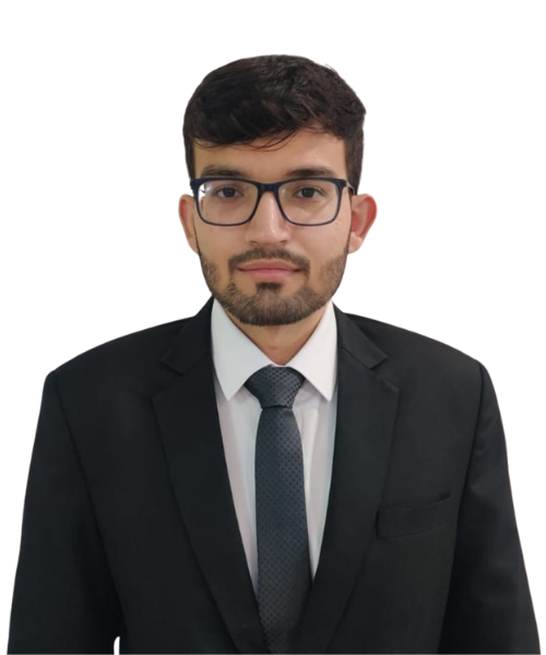 Professional headshot of a man wearing a black suit, white shirt, gray tie, and glasses against a plain background, looking at the camera.