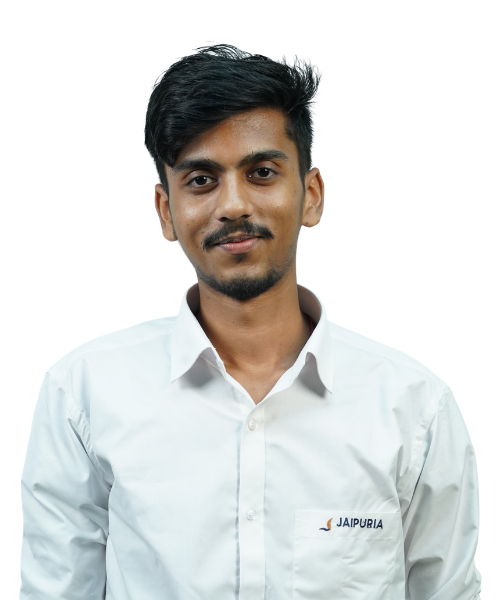 Portrait of a young man with dark hair and a light beard, wearing a white button-down shirt with a Jaipuria logo on the chest pocket, looking at the camera.